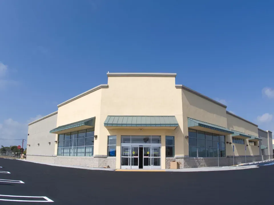 An empty store with a parking lot in front of it