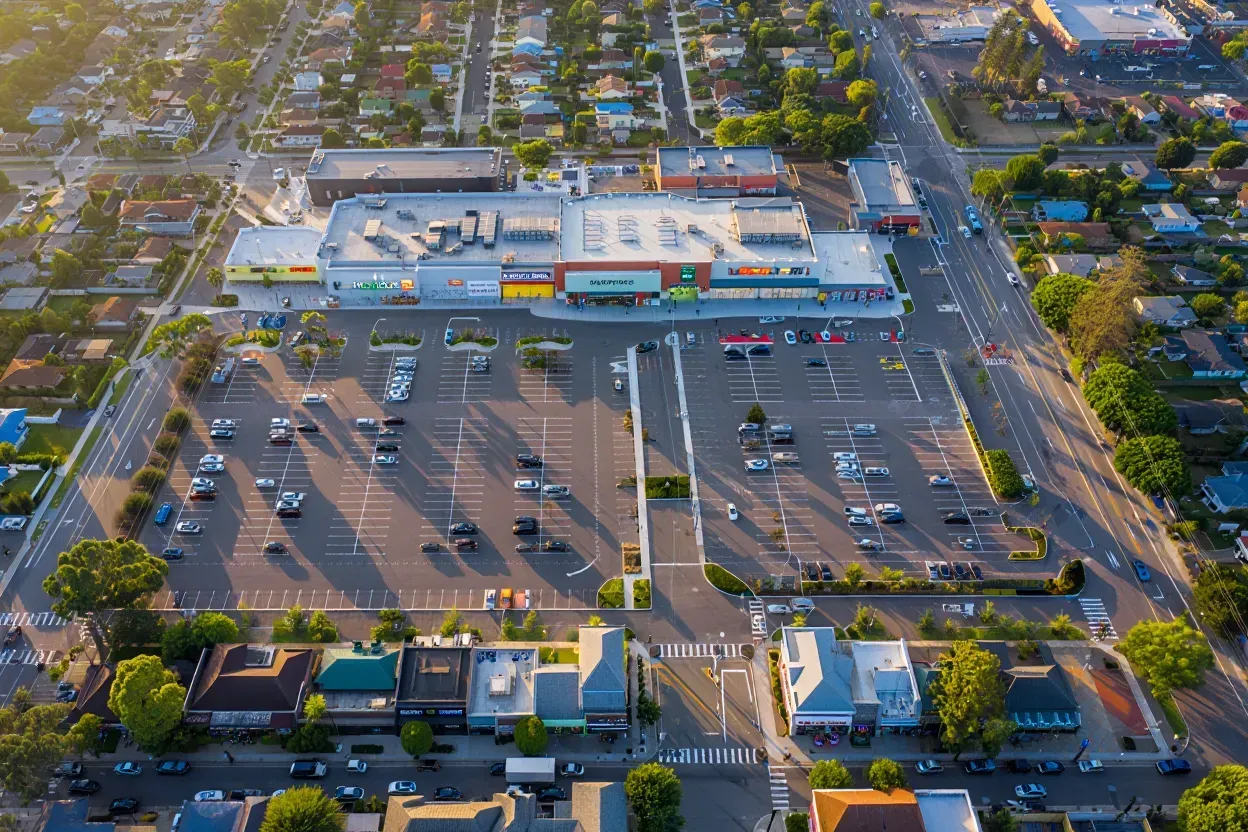 A green Publix Food & Pharmacy sign mounted on a white and beige building exterior against a blue sky.
