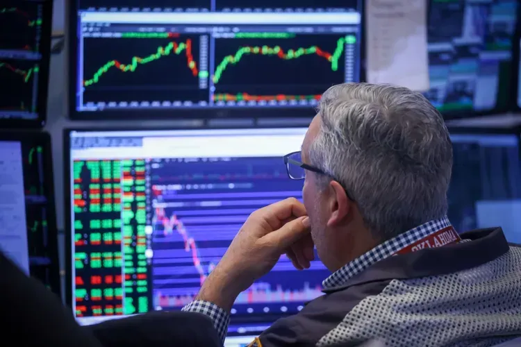 A blurred image of a city street with people walking down it.