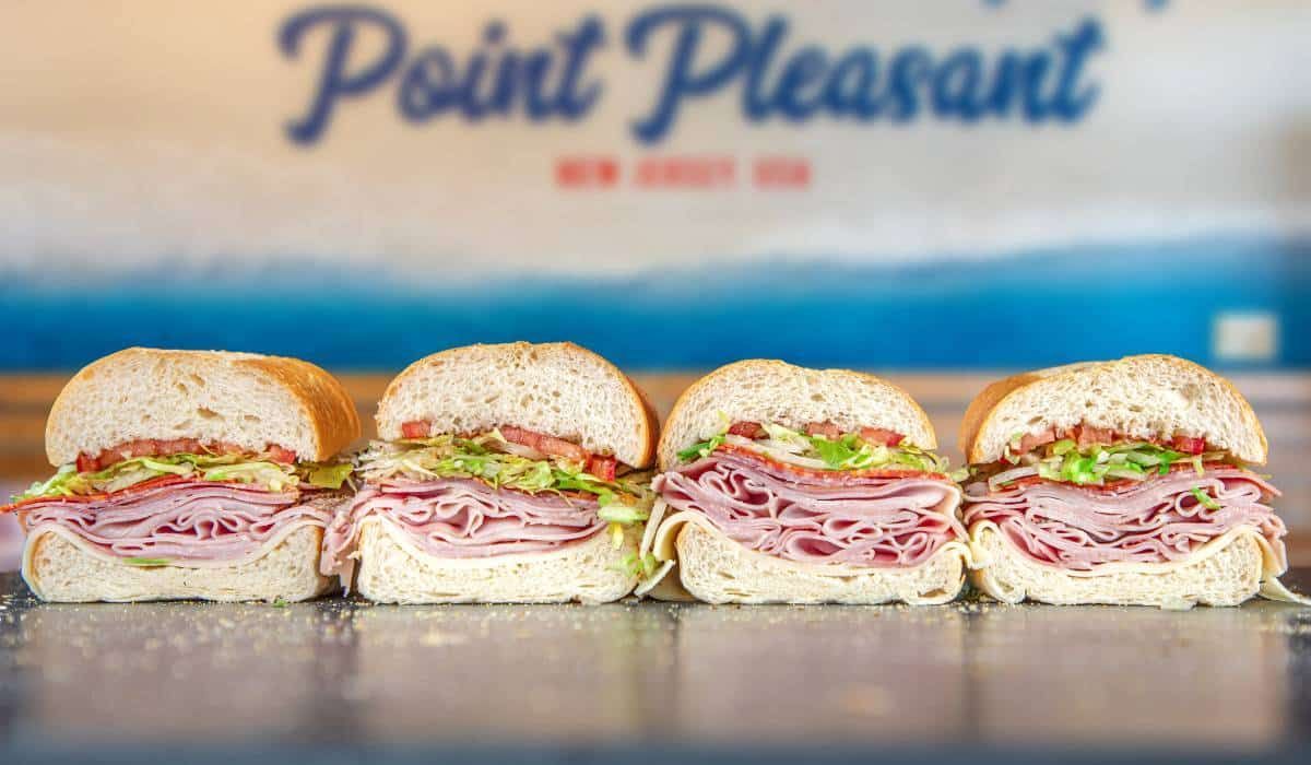 A modern two-story commercial office building with a stone-accented entrance at dusk, seen from a paved parking lot.