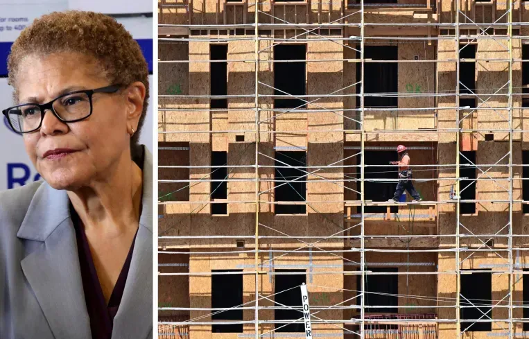 A woman is standing next to a picture of a building under construction.