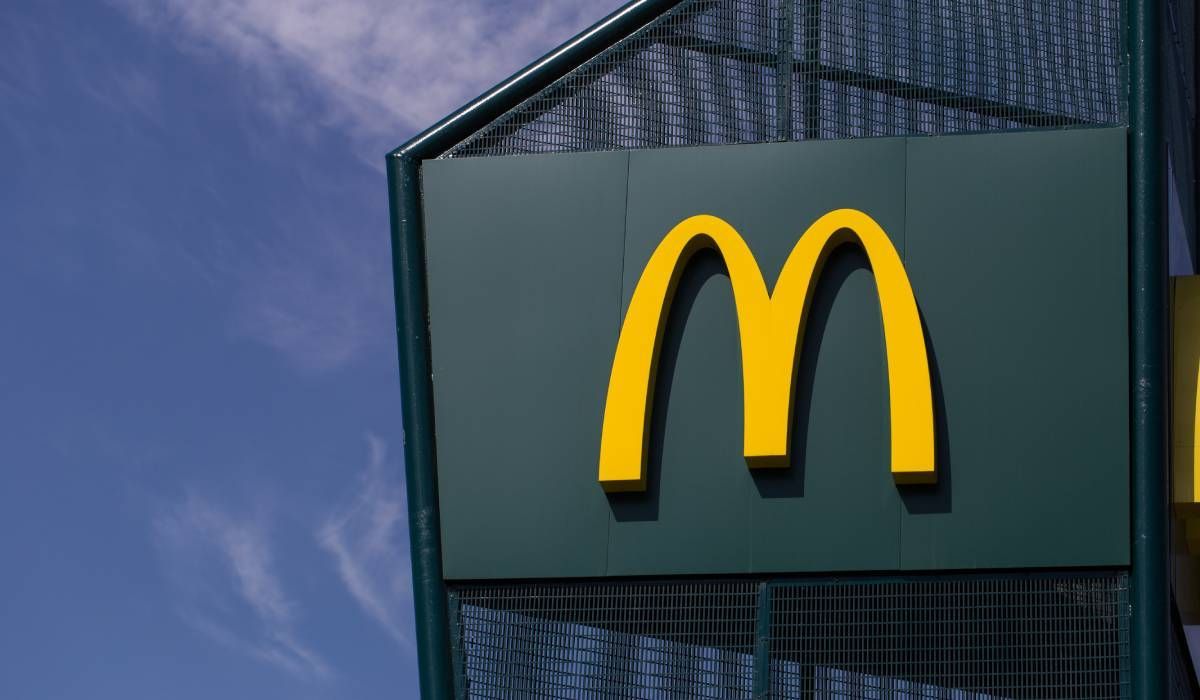A mcdonald 's sign with a blue sky in the background