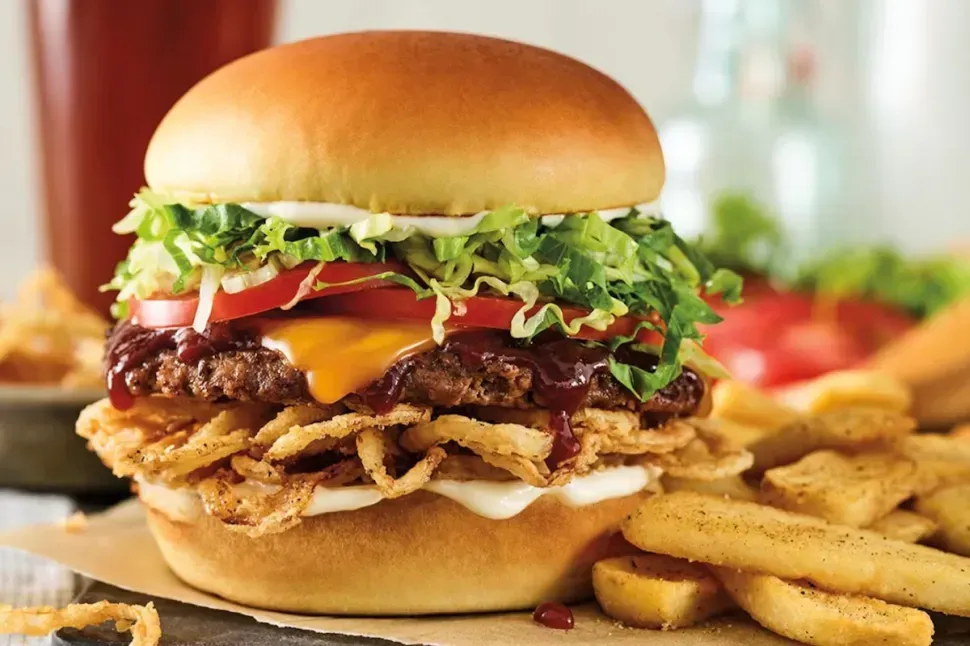 A close up of a hamburger and french fries on a table.