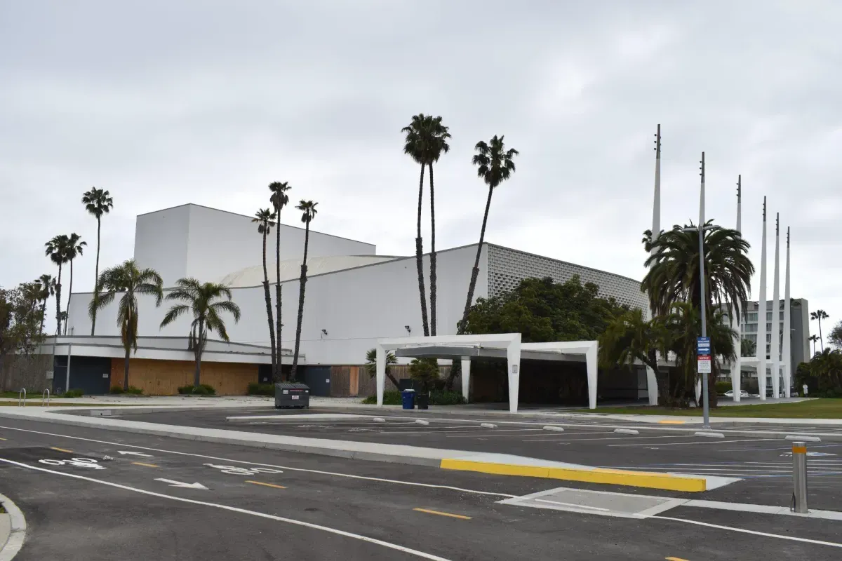A large white building with palm trees in front of it
