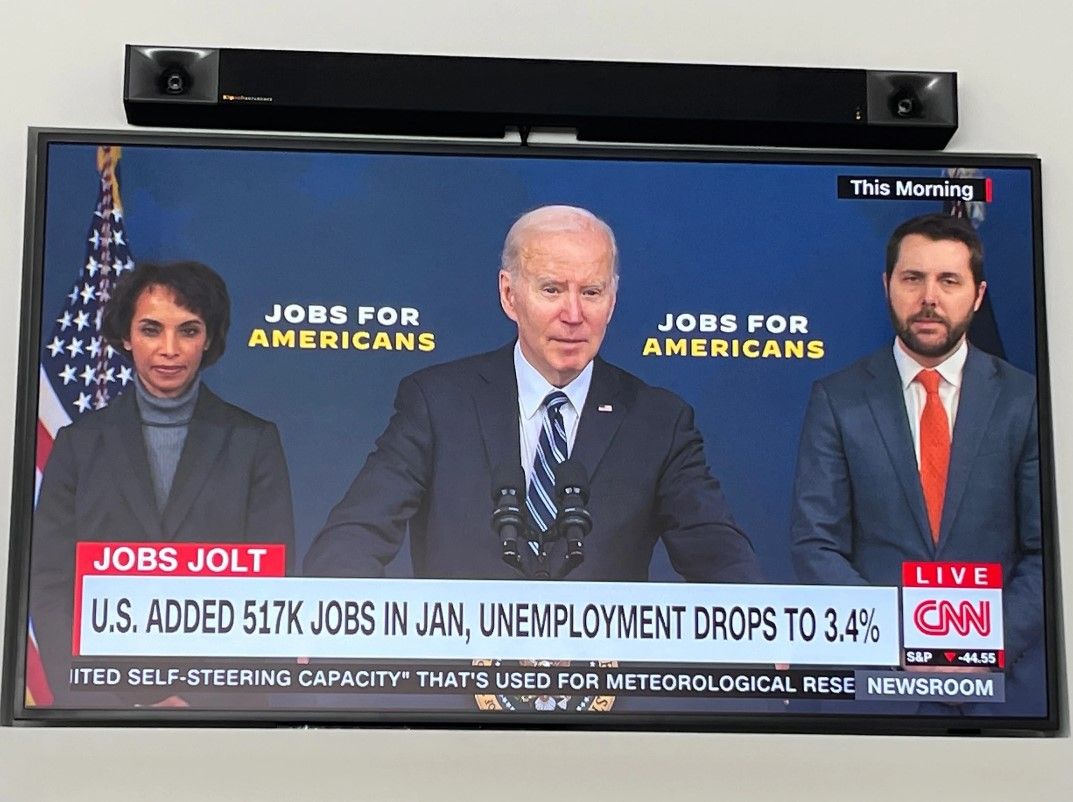 A tv screen shows a news report about jobs for americans