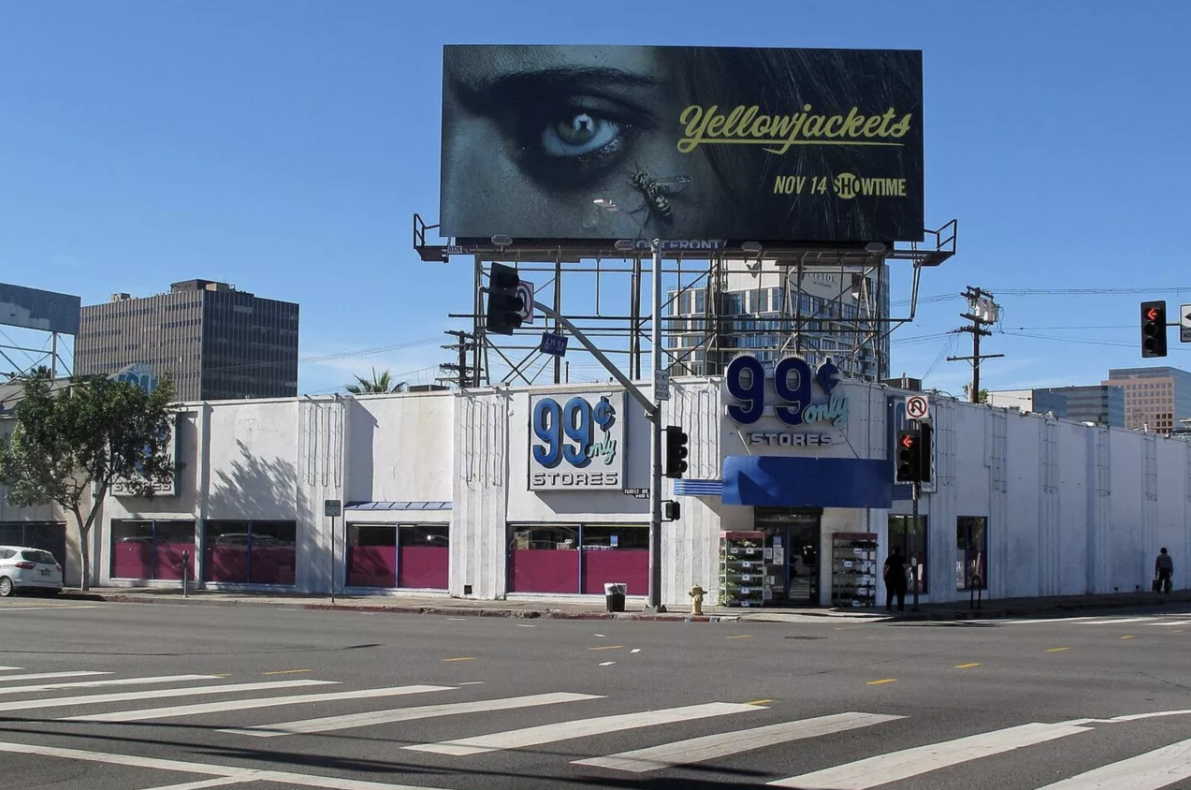 A billboard for yellowjackets is above a 99 cent store