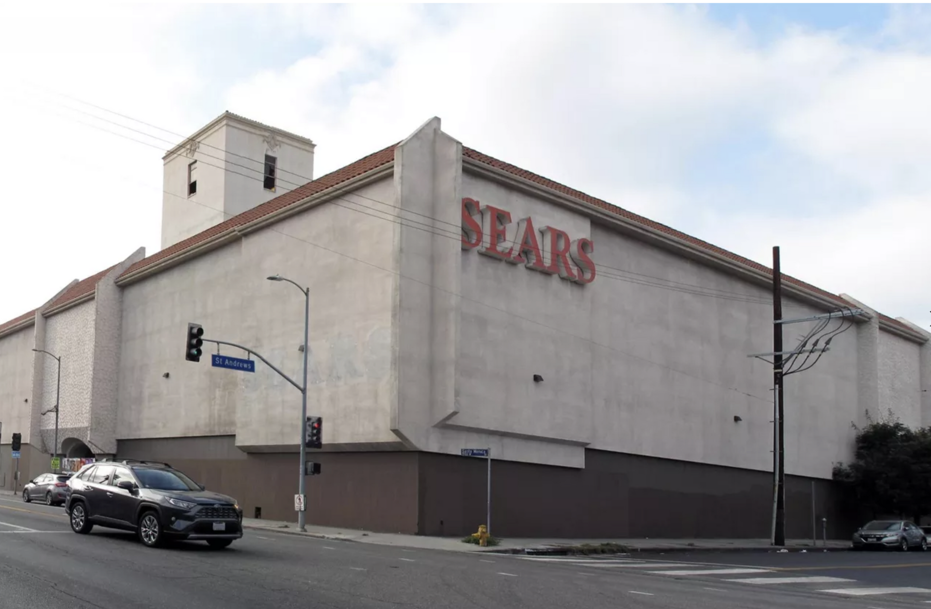 A sears store is on the corner of a street