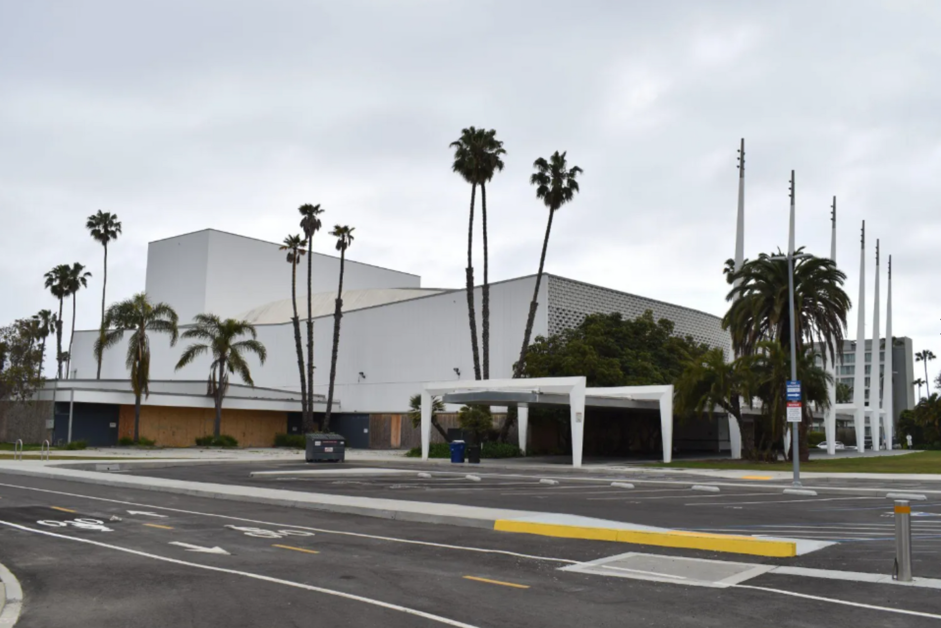 A large white building with palm trees in front of it