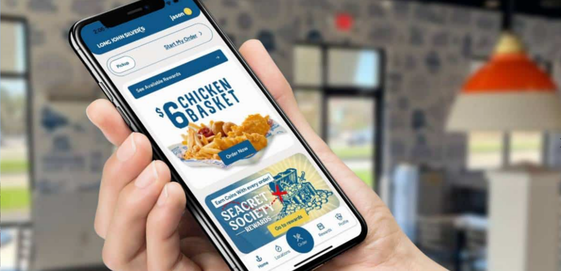 A person is holding a cell phone with a chicken basket app on it.