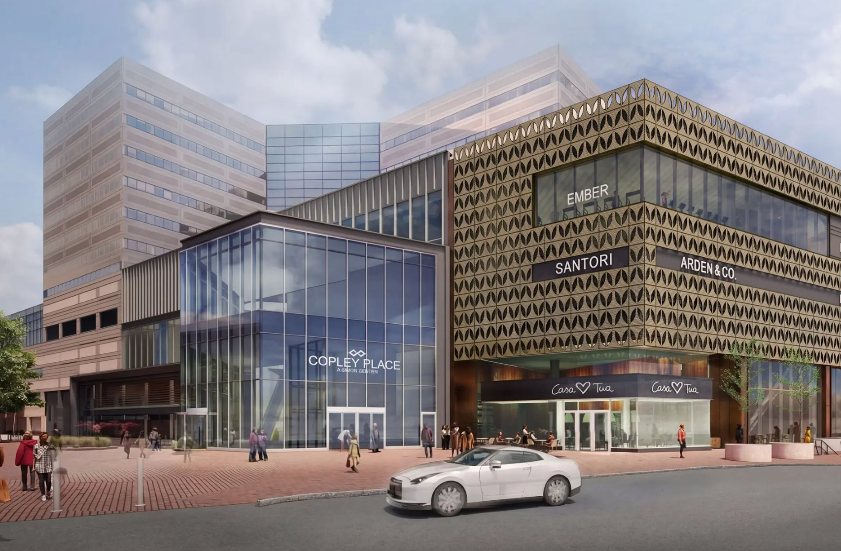 An elevated outdoor view of a modern shopping mall promenade with manicured greenery, palm trees, and pedestrians.