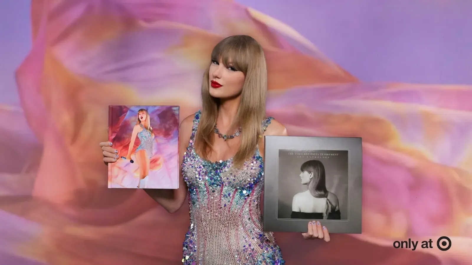 A woman in a dress is holding two albums in her hands.