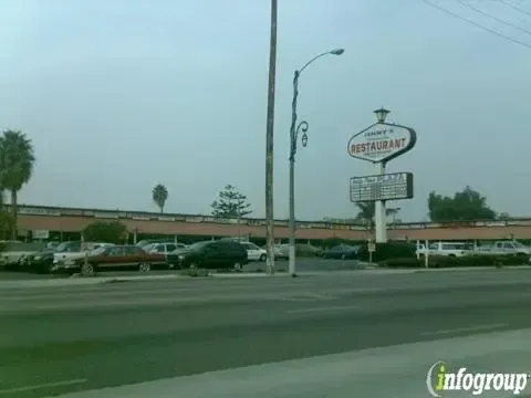 A parking lot with cars parked in front of a restaurant sign
