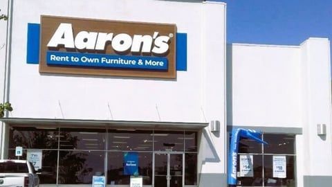 A white building with a brown sign that says aaron 's