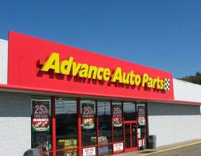 A red and white advance auto parts store with a blue sky in the background