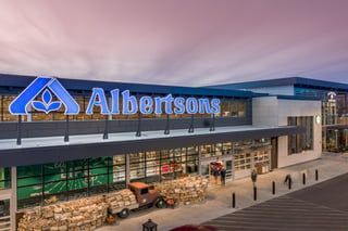 An aerial view of an albertsons grocery store with a truck parked in front of it.