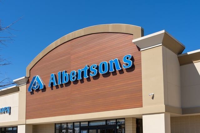 The front of a albertsons grocery store with a blue sign on it.