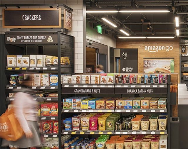 A woman is walking through an amazon go grocery store.