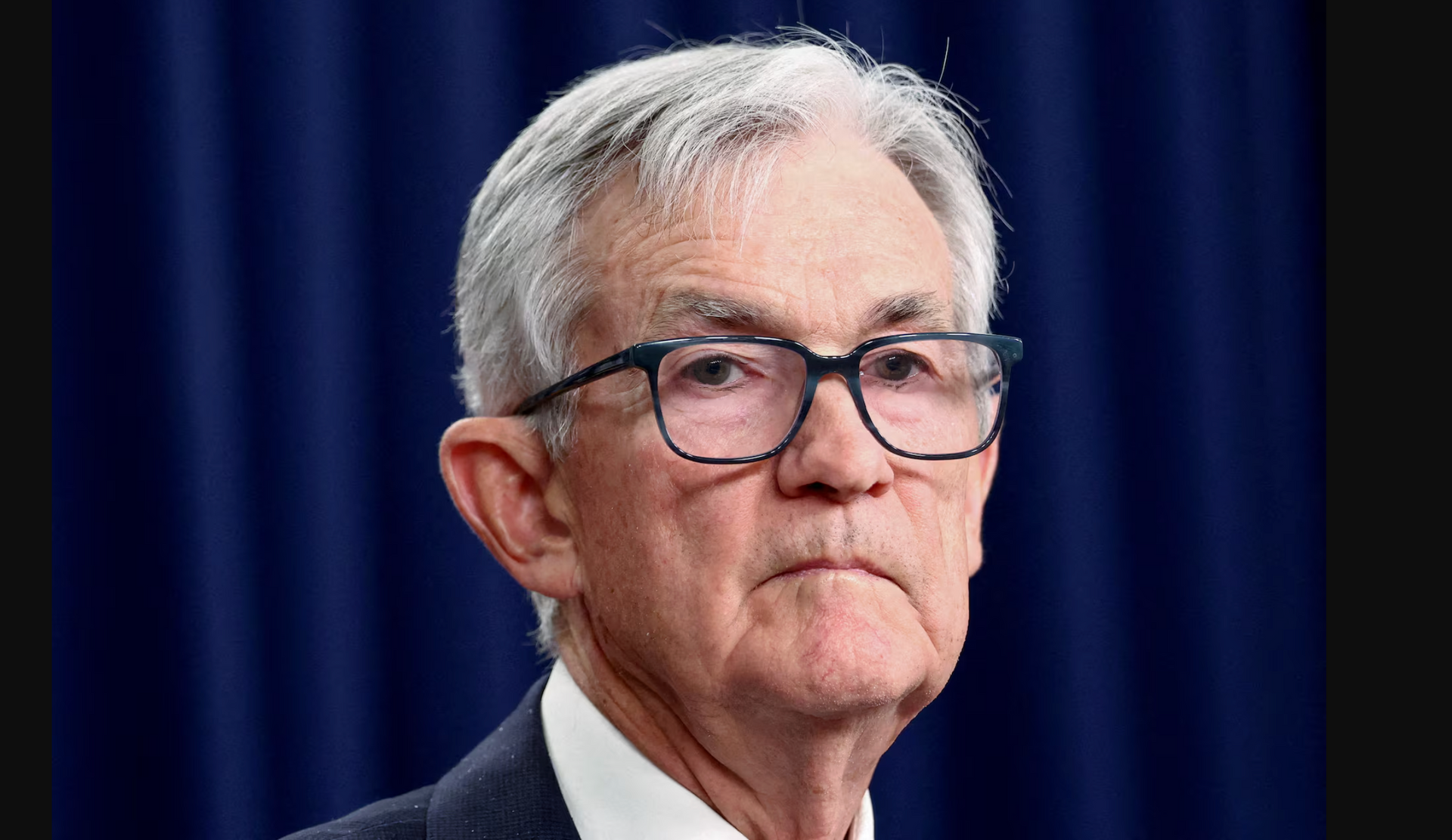 A modern two-story commercial office building with a stone-accented entrance at dusk, seen from a paved parking lot.