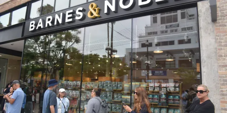 A group of people are standing outside of a barnes & noble store.