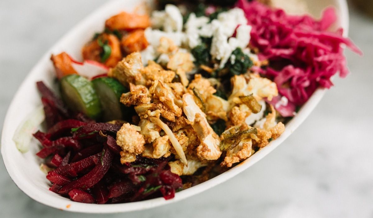 A white bowl filled with a variety of vegetables on a table.