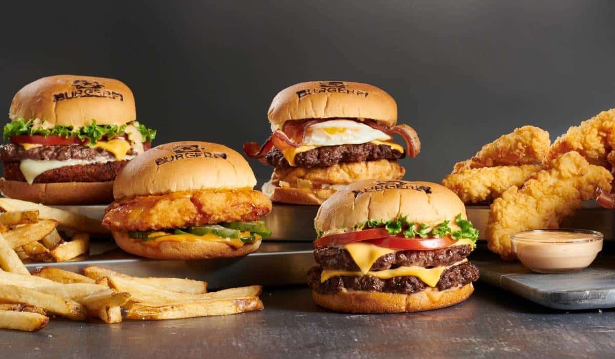 There are many different types of hamburgers and french fries on the table.