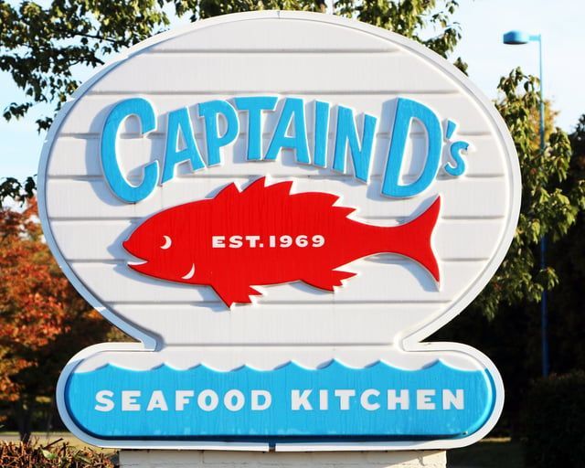 A sign for captain 's seafood kitchen has a red fish on it