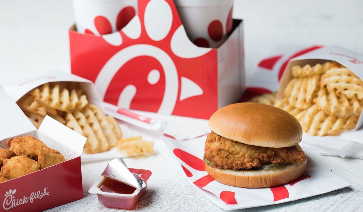 A chicken sandwich , french fries , and chicken nuggets are on a table.