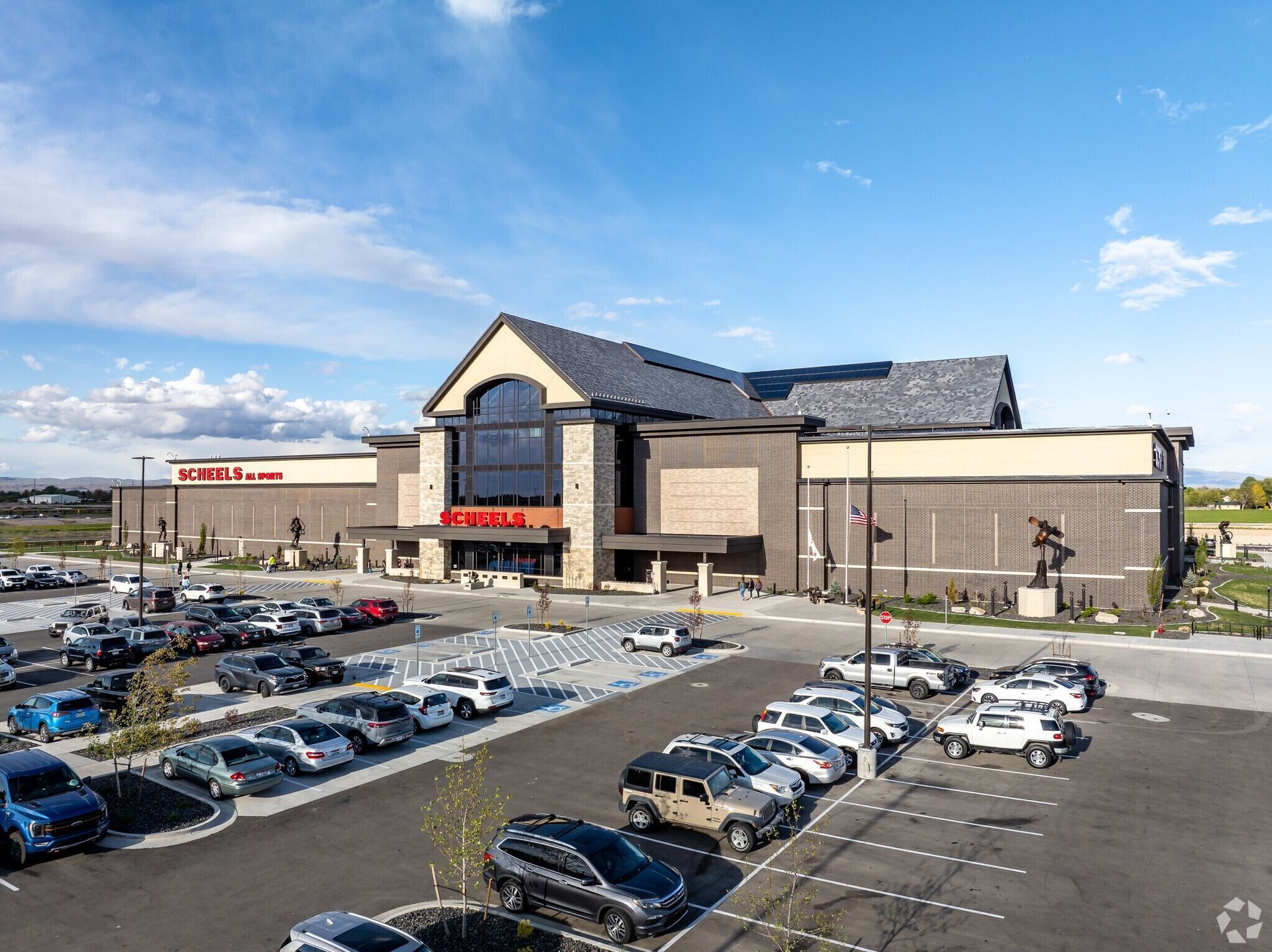 A large building with a lot of cars parked in front of it.