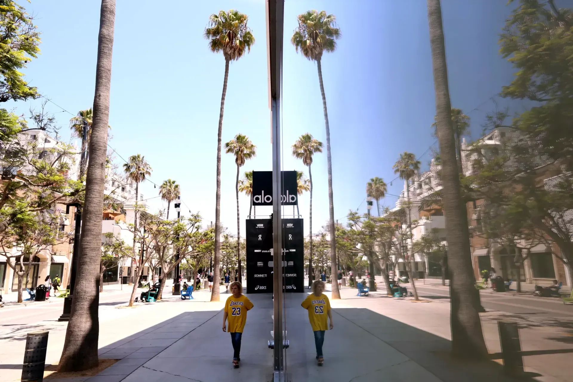 Two people walking in front of a sign that says adidas