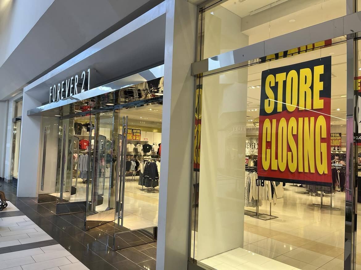 A store with a sign in the window that says store closing