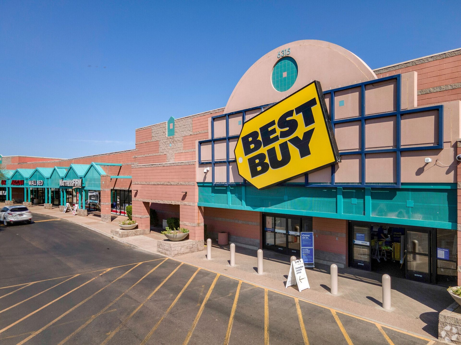 An aerial view of a best buy store with cars parked in front of it