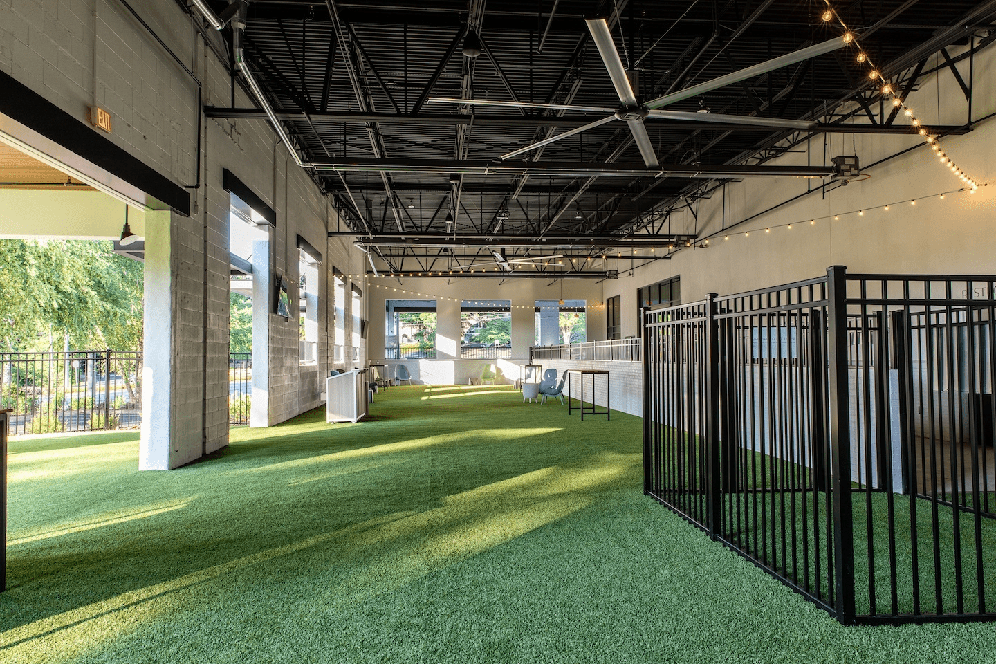 A large room with a lot of windows and a fence in the middle of it.