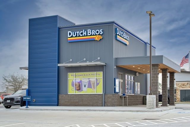 A dutch bros store with a truck parked in front of it.