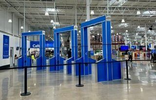 A large store with a lot of blue signs and a black barrier.