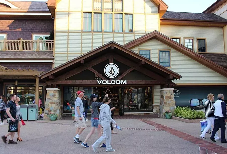 A group of people are walking in front of a volcom store