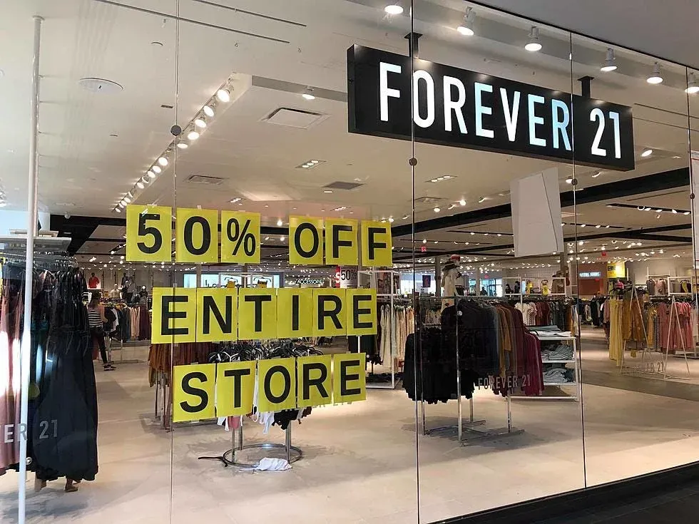 A store front with a sign that says `` 50 % off entire store ''.