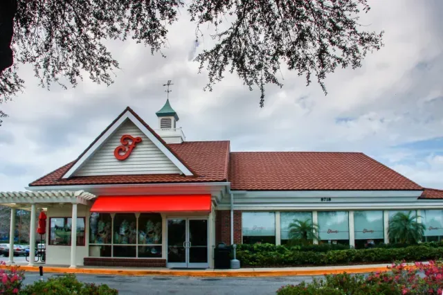 A restaurant with a red awning that says j on it