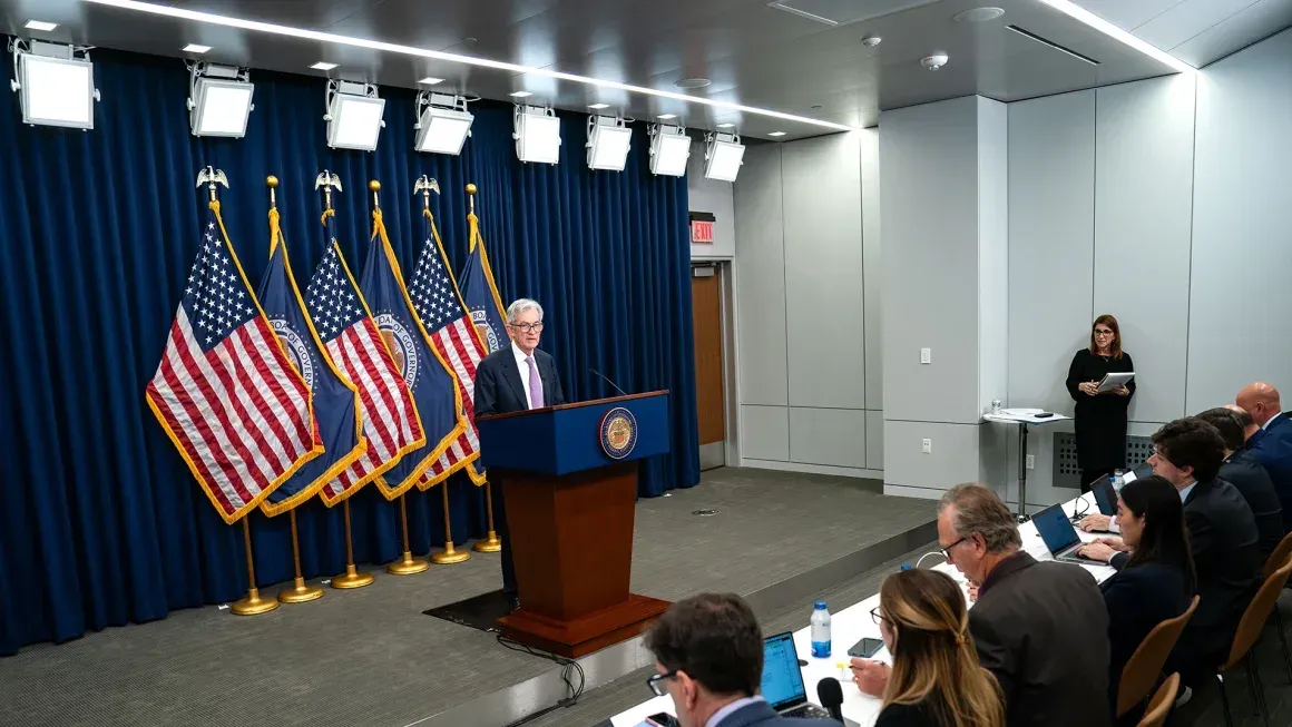 A man is standing at a podium in front of a group of people.