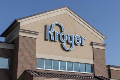 The front of a kroger grocery store with a blue sky in the background.