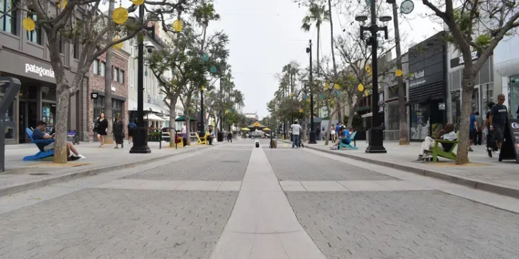 A blurred image of a city street with people walking down it.