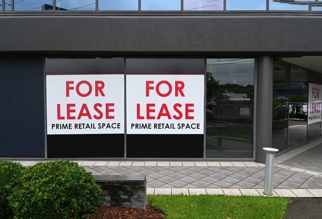 A building with two for lease signs on the windows