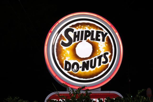 A shipley donuts sign is lit up at night