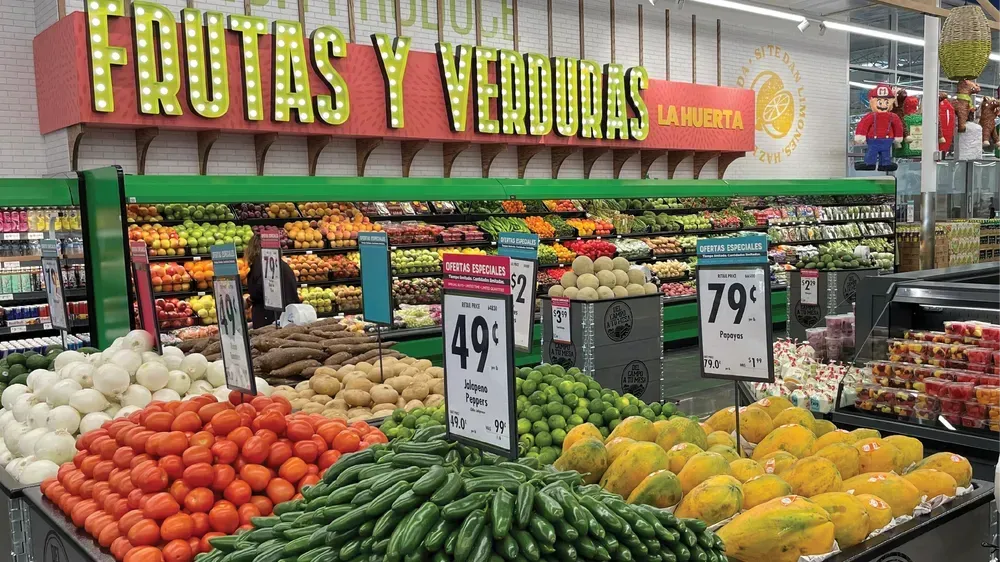 A variety of fruits and vegetables are displayed in a grocery store.