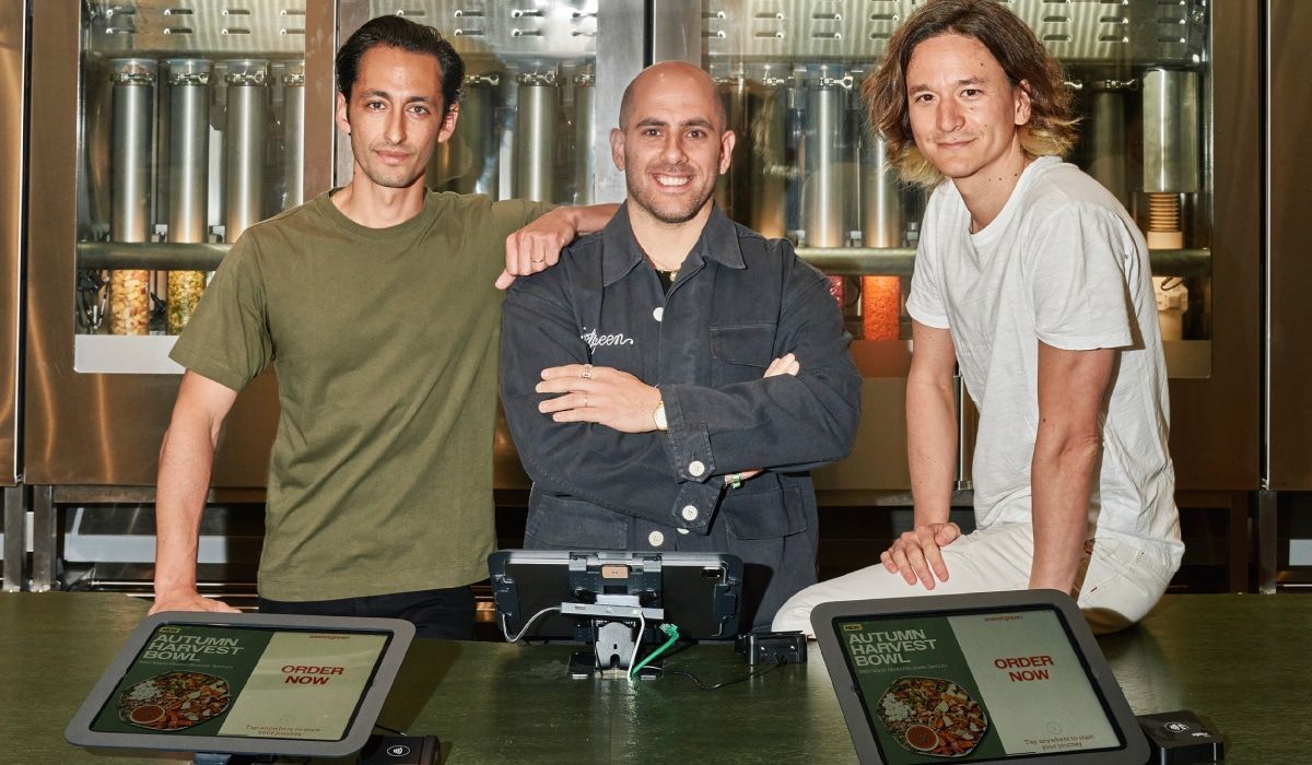 Three men are posing for a picture in a restaurant.