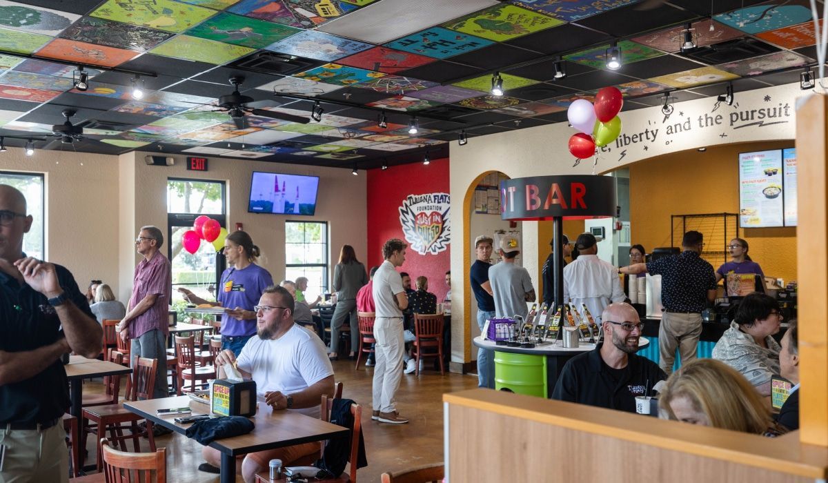 A group of people are sitting at tables in a restaurant.