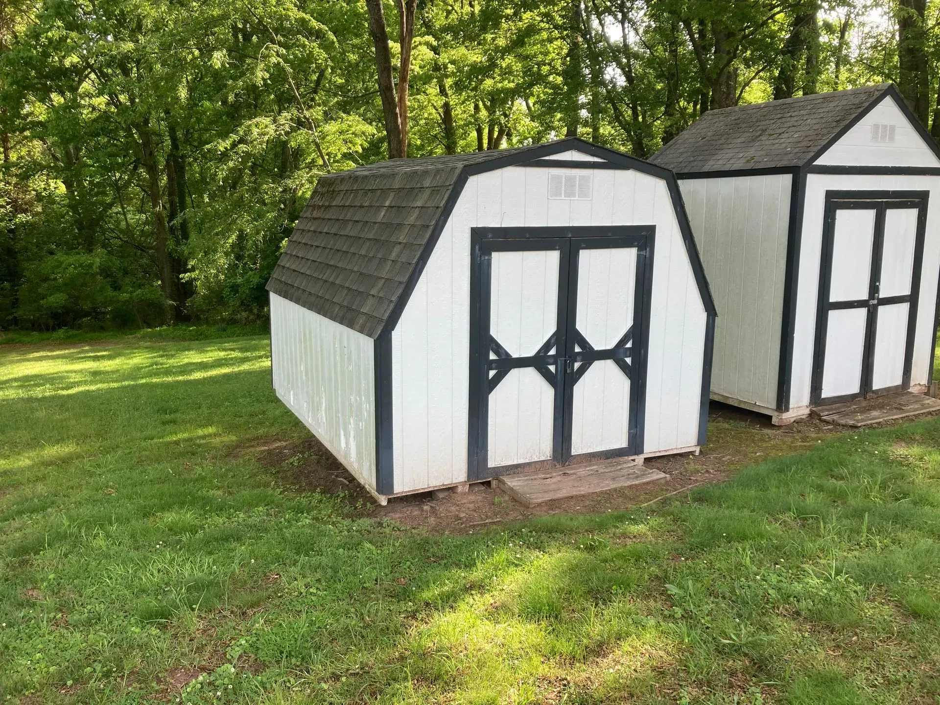 A mattress and a rug are sitting on the sidewalk in front of a house.