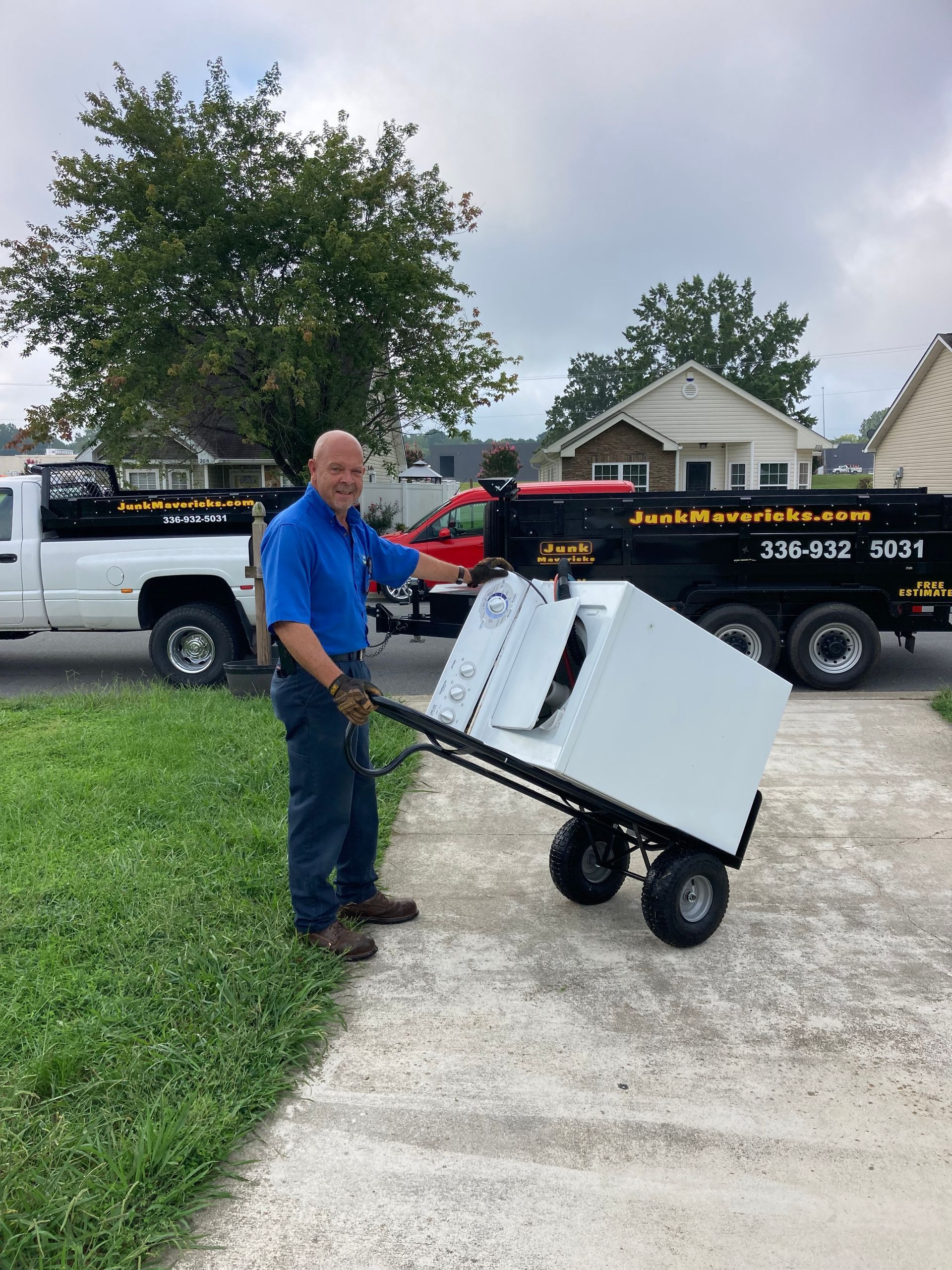 A blue dumpster filled with lots of trash is sitting next to a pile of dirt.