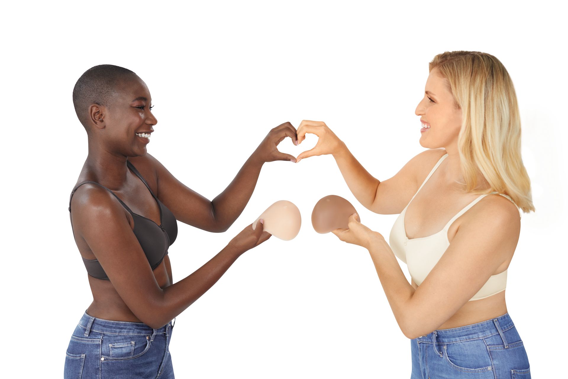 Two women in bras are making a heart shape with their hands.