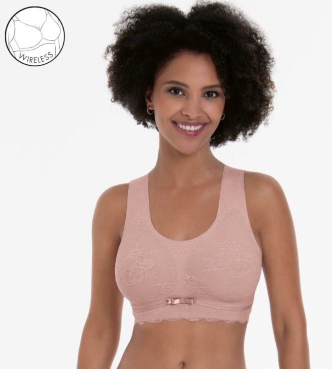 A woman is wearing a pink sports bra and smiling