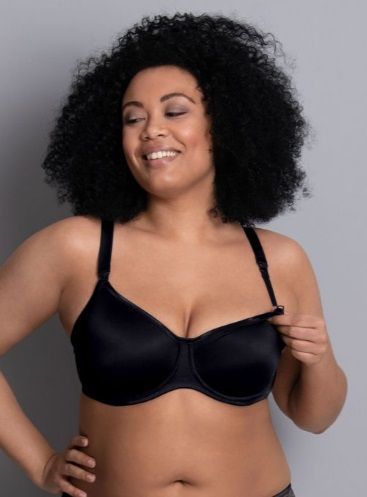 A woman is wearing a black bra and smiling.